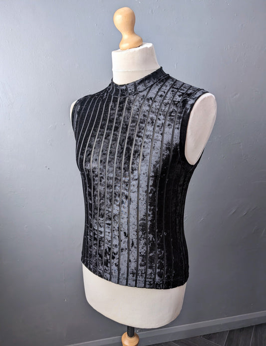 Black sleeveless velvet top on a mannequin against a gray background