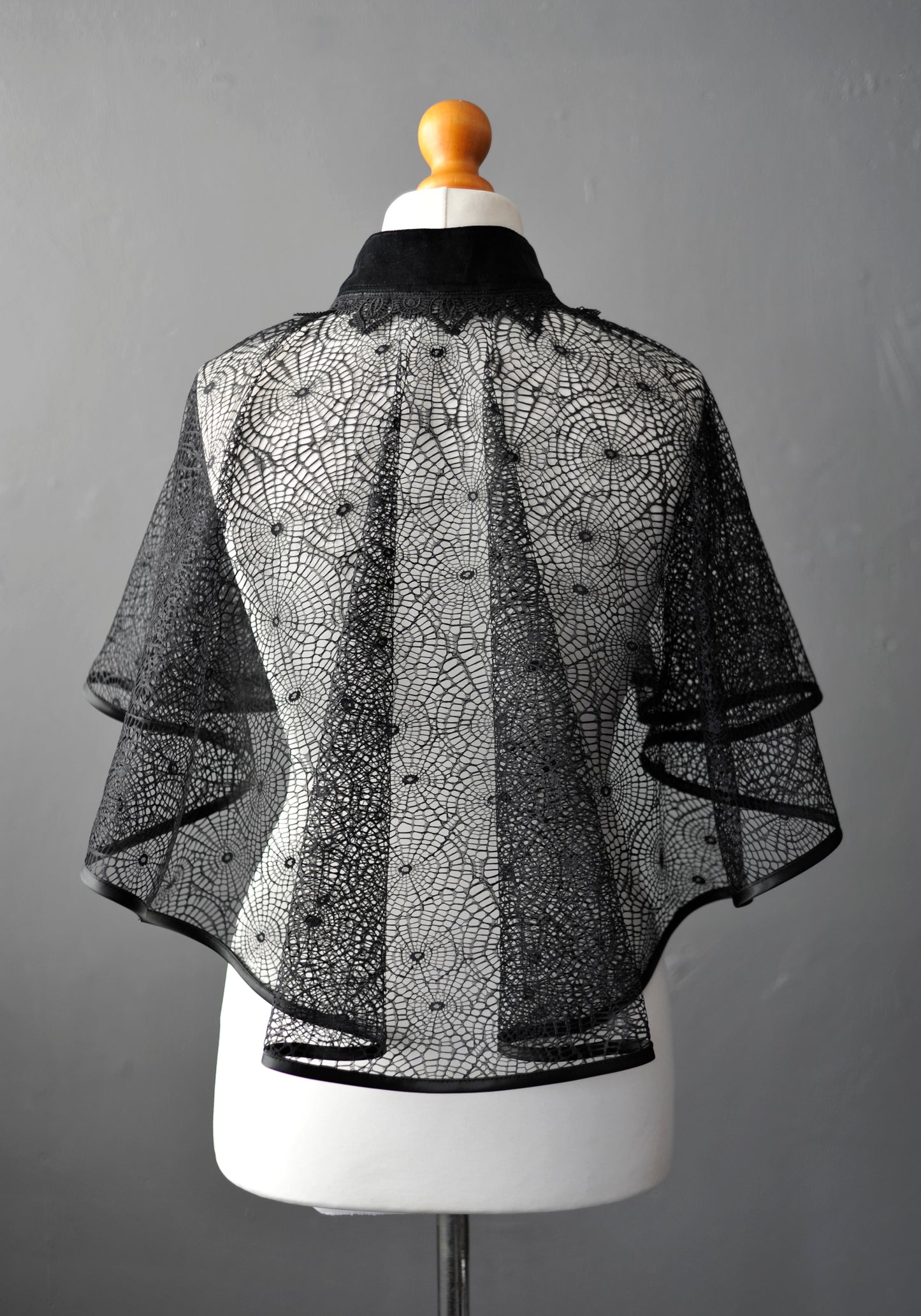 Sheer spider cloak on a mannequin against a gray background