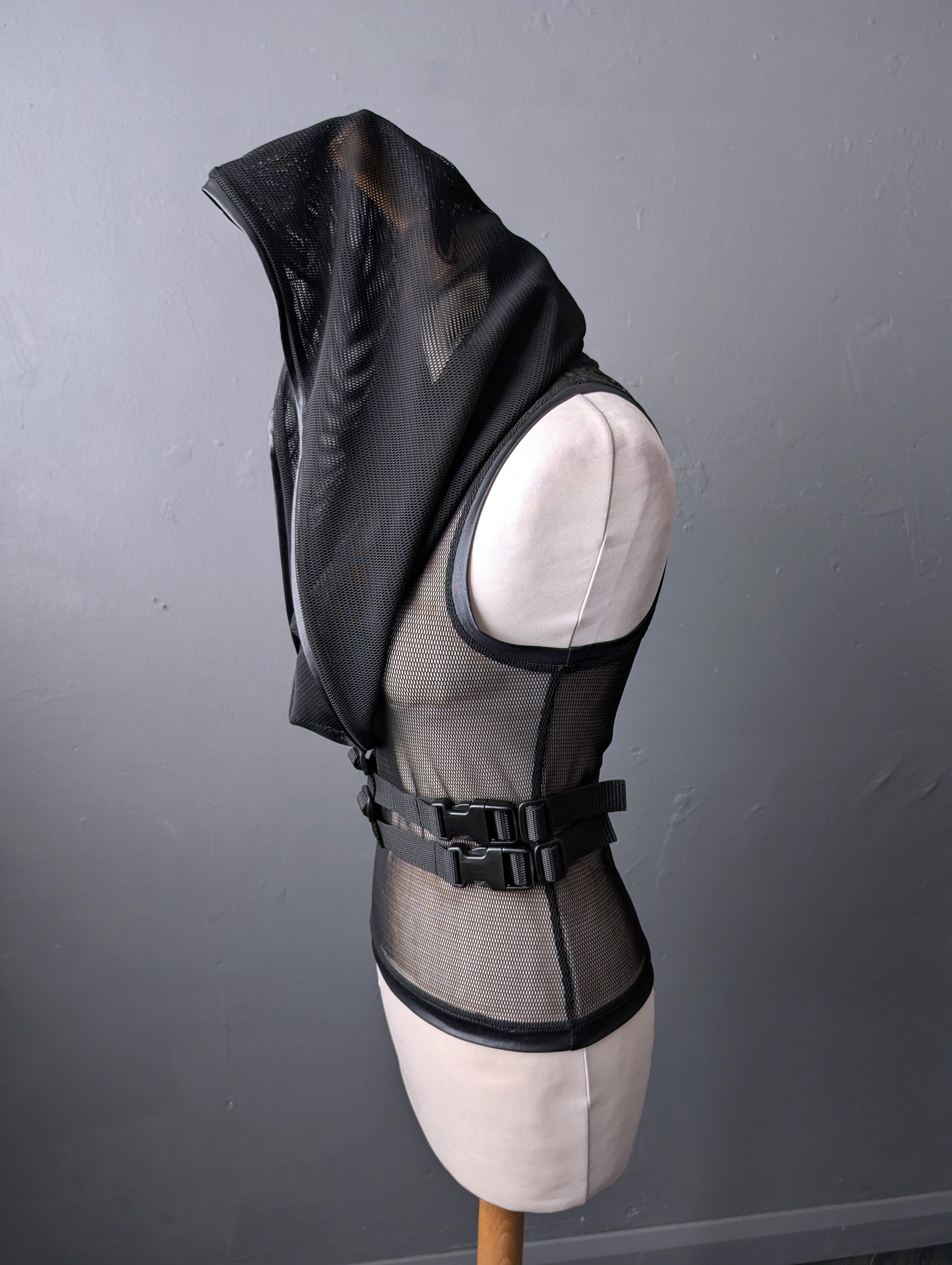 Black sleeveless mesh tank top on a mannequin against a gray background