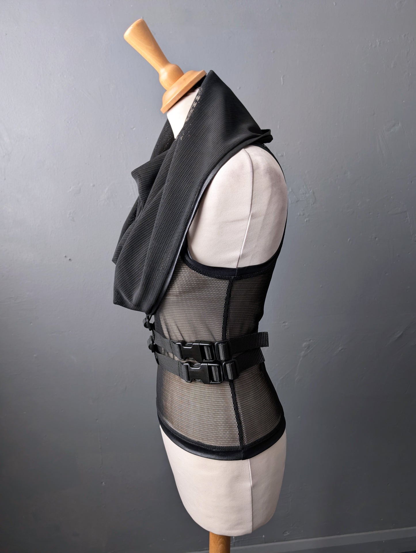 Black mesh vest on a mannequin against a gray background