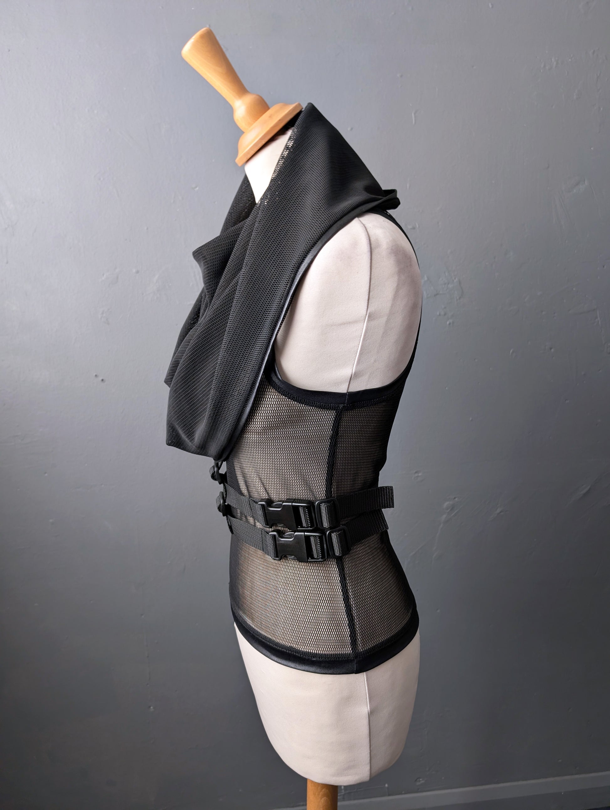 Black mesh vest on a mannequin against a gray background